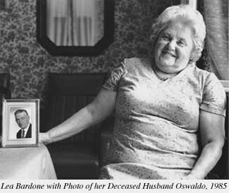 Photograph of Lea Bardone with photo of her deceased husband Oswaldo, 1985
